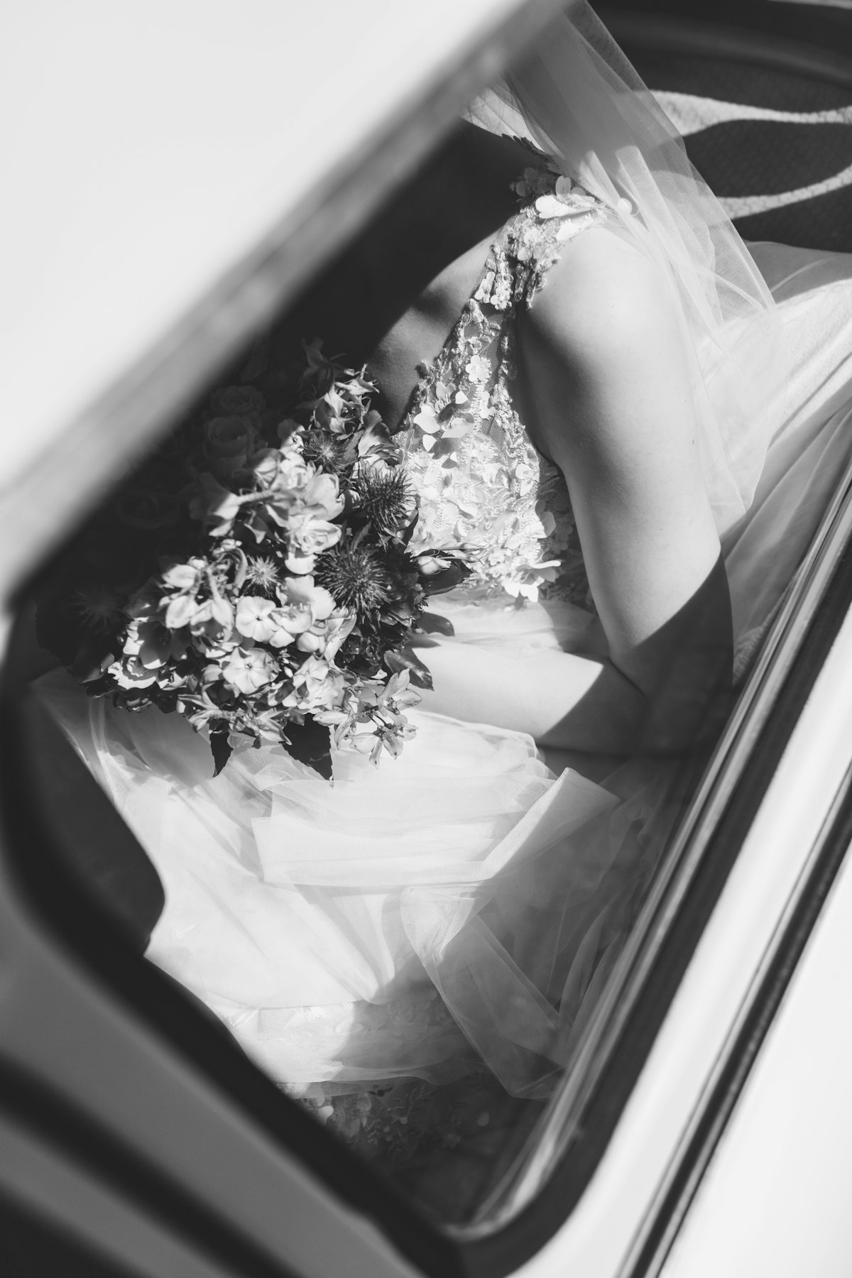 Bride with bouquet in a wedding car